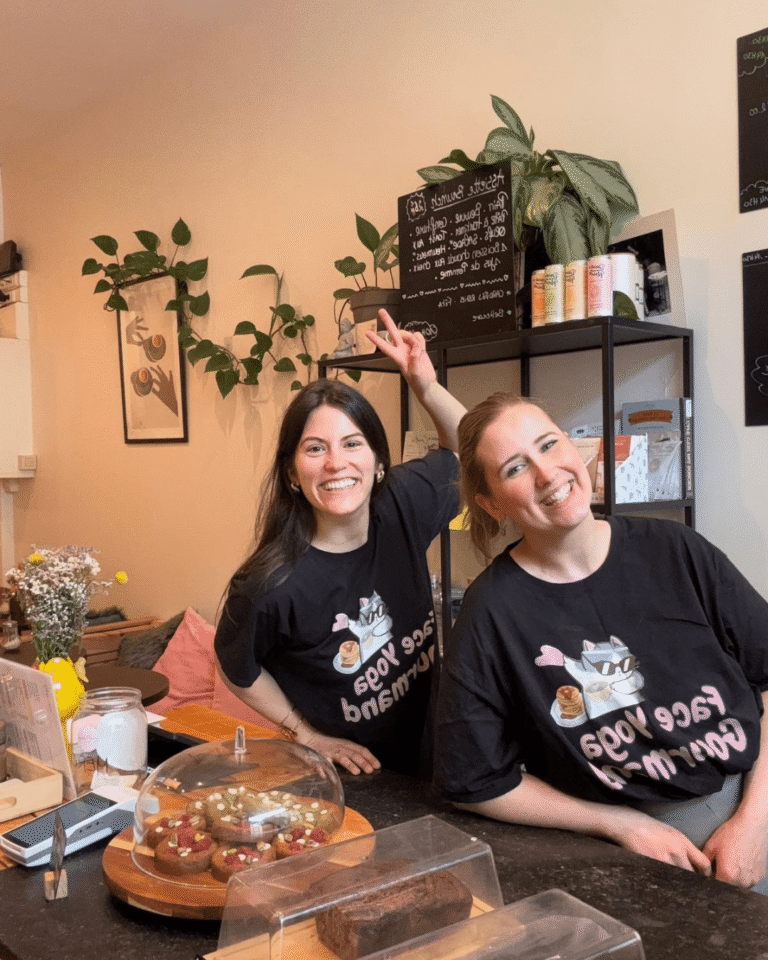 Deux membres de l’équipe Face Yoga Gourmand souriantes derrière le comptoir de La Tasse