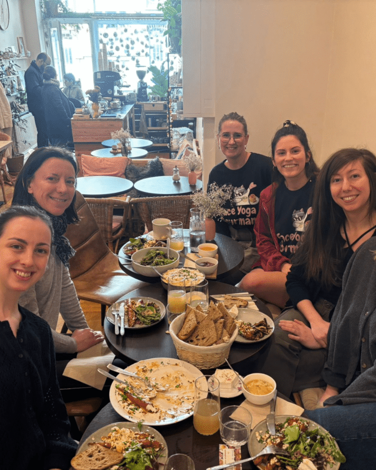 Clientes attablées dégustant un brunch sain dans le cadre d’un atelier Face Yoga Gourmand.