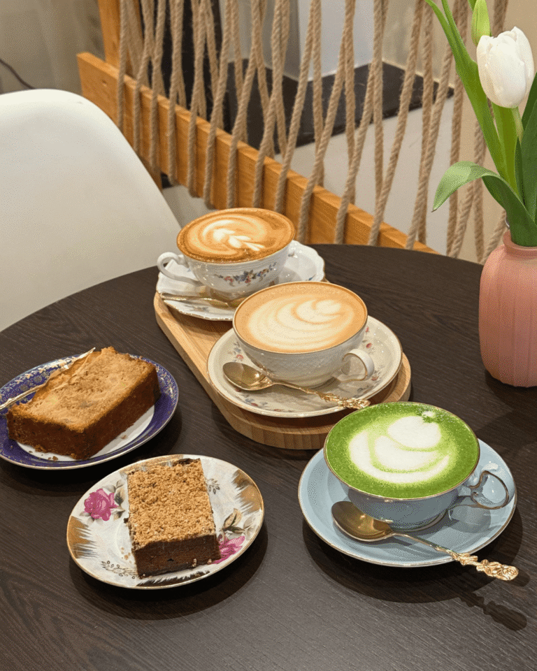 Lattes, matcha et parts de gâteau maison servis sur vaisselle vintage au café La Tasse